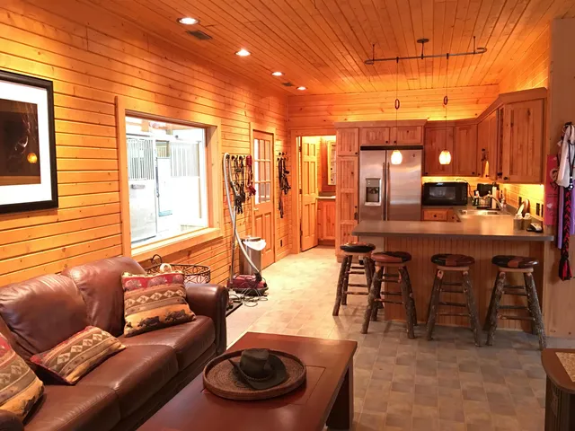 a kitchen with stainless steel appliances granite countertop a refrigerator a stove and a sink with wooden cabinets