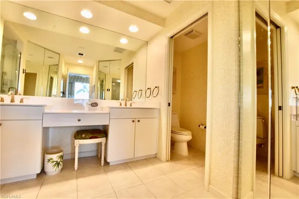 a bathroom with a sink a toilet and a large mirror