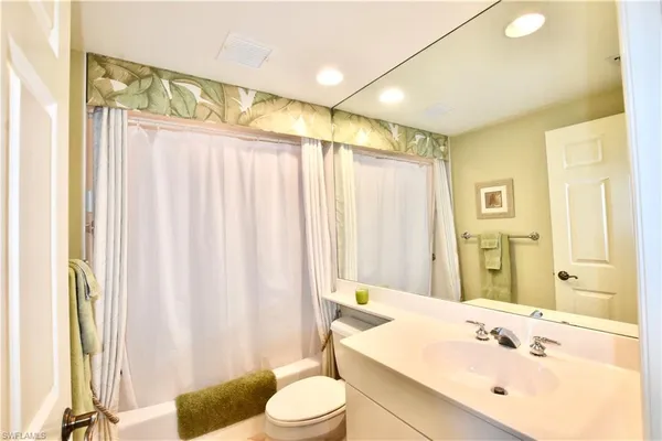 a bathroom with a sink a toilet and shower curtain