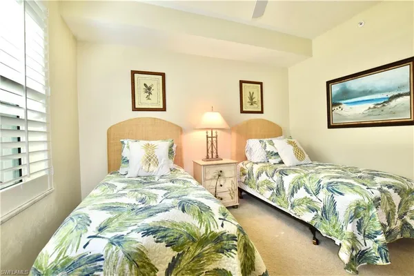 a bedroom with two bed and a painting on the wall