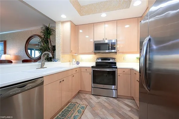 a kitchen with stainless steel appliances a refrigerator sink and microwave