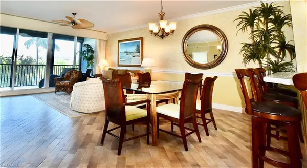 a dining room with furniture a chandelier and wooden floor