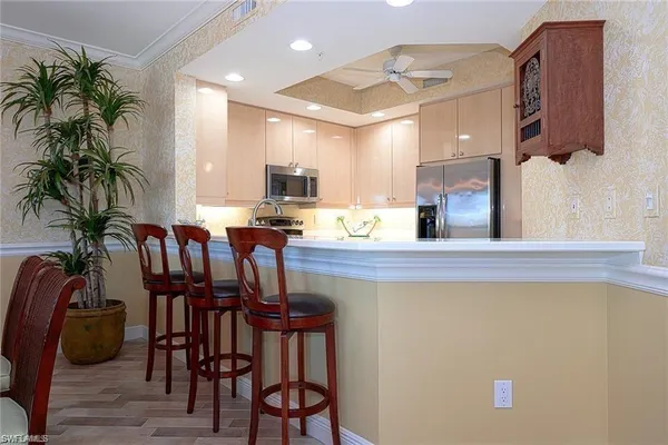 a kitchen with stainless steel appliances a table and chairs in it