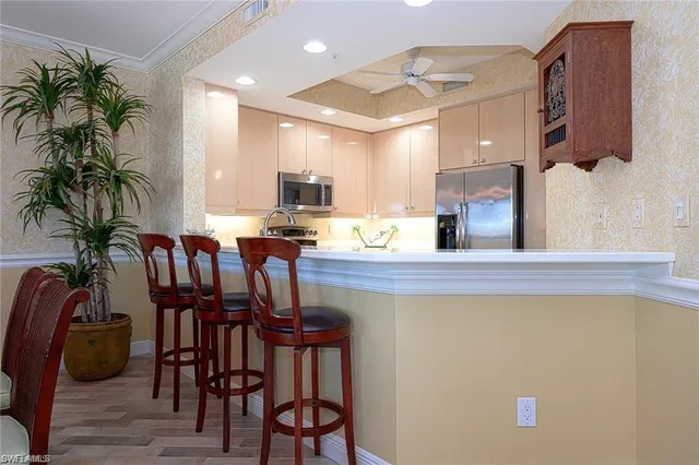 a kitchen with stainless steel appliances a table and chairs in it