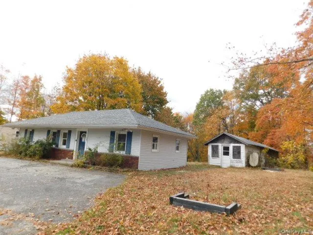 a view of a yard in front of a house with large trees