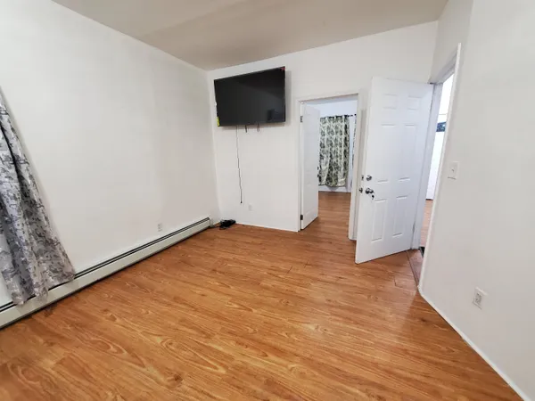 a view of a livingroom with wooden floor and a flat screen tv