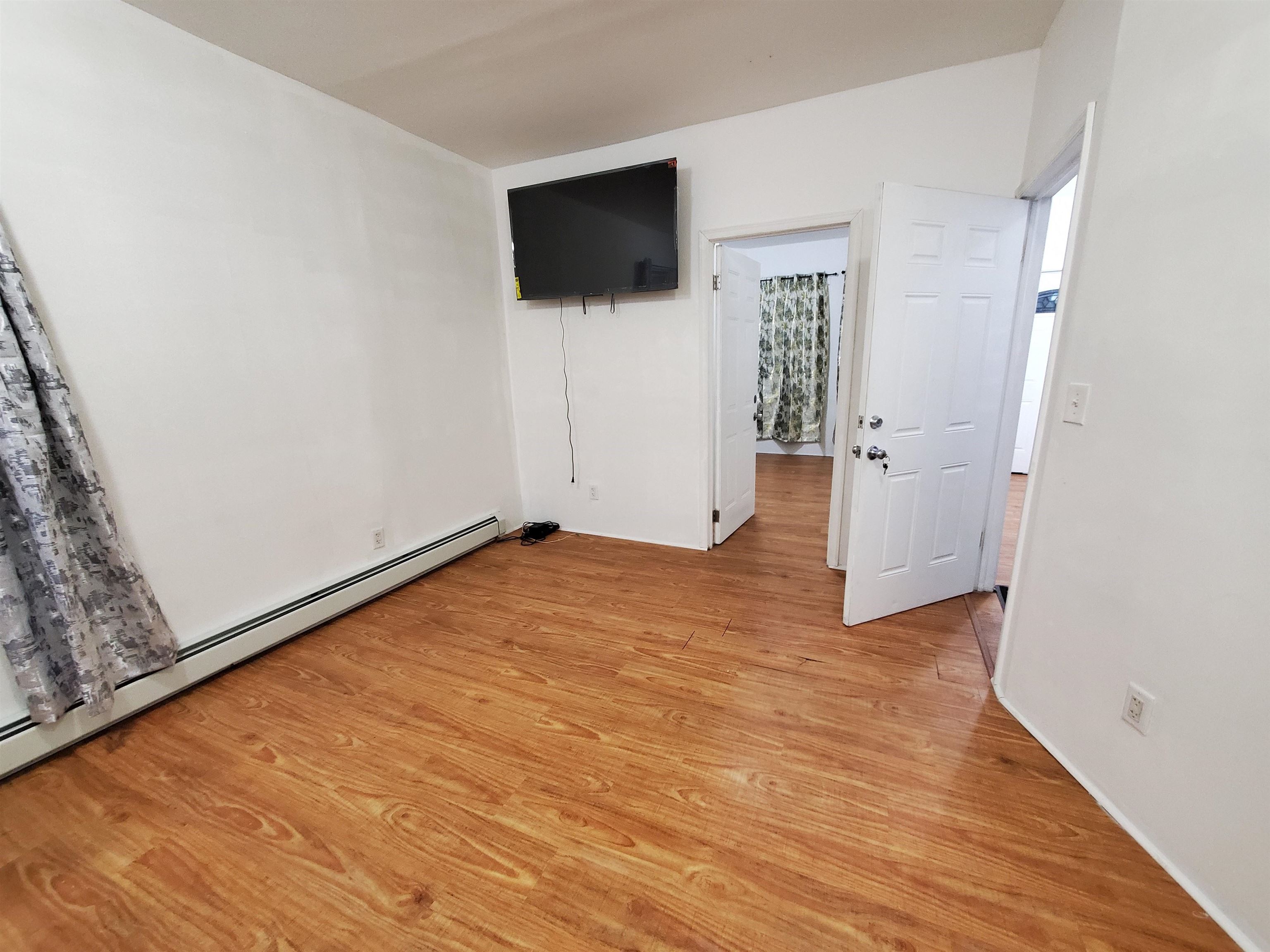 140 West 3rd Street, Unit 1 Bayonne, NJ 07002 - Photo 5 of 8 a view of a livingroom with wooden floor and a flat screen tv