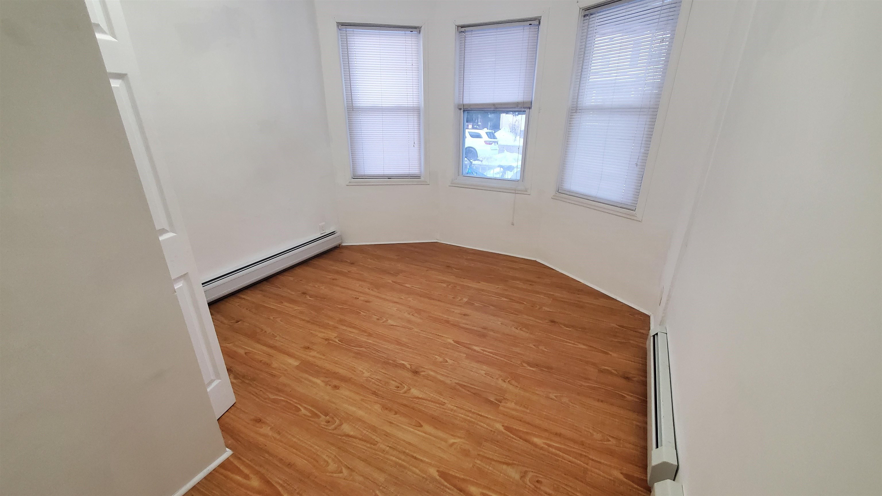 140 West 3rd Street, Unit 1 Bayonne, NJ 07002 - Photo 6 of 8 an empty room with windows