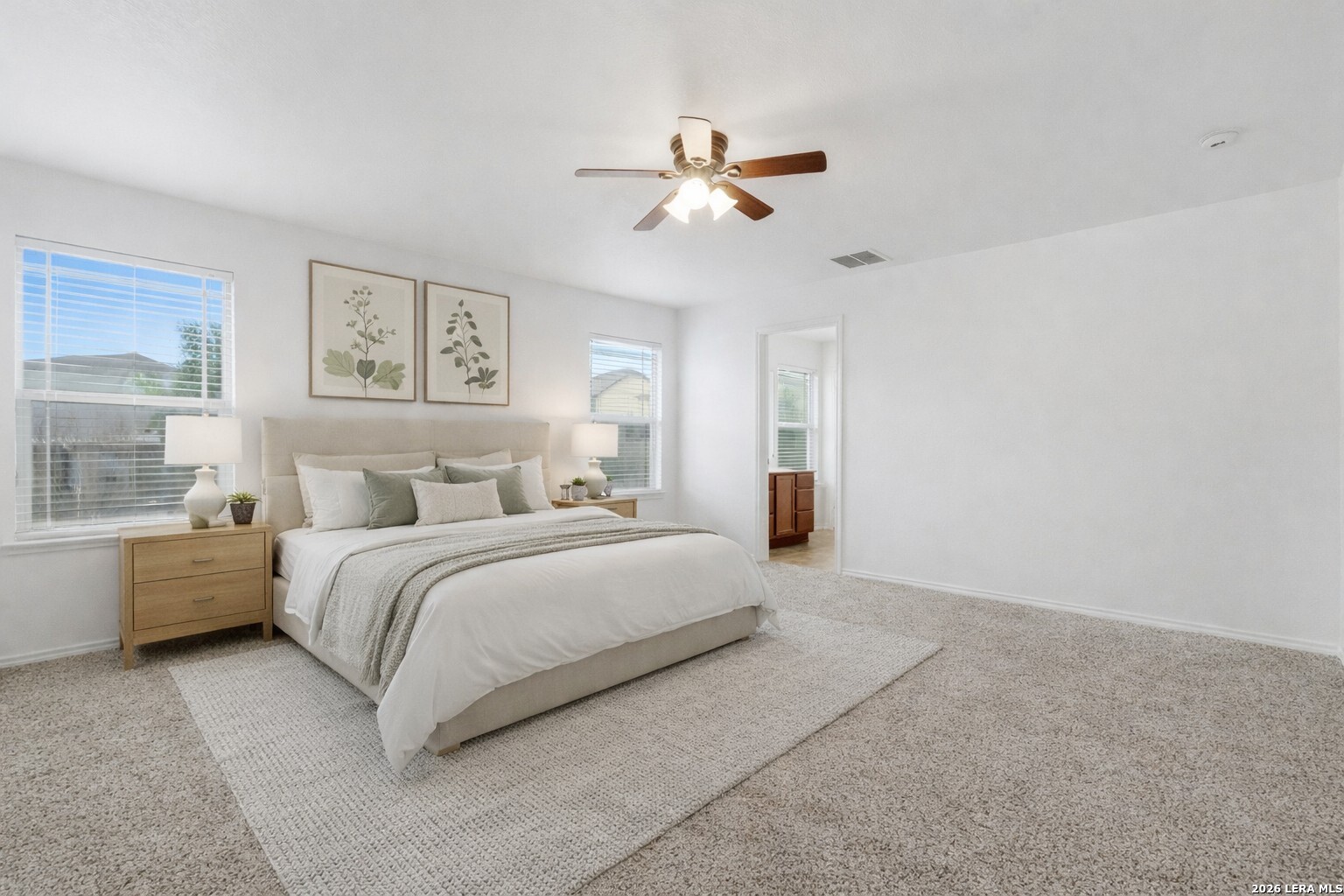 9819 Hawk Shore Converse, TX 78109 - Photo 12 of 26 a spacious bedroom with a bed and a chandelier