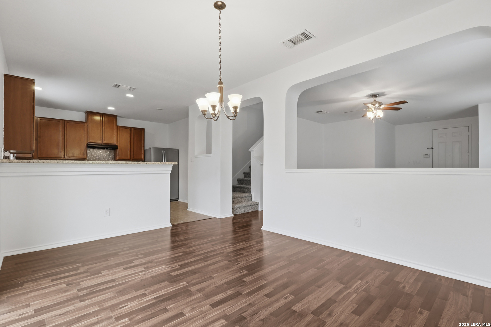 9819 Hawk Shore Converse, TX 78109 - Photo 6 of 26 a view of a kitchen with a refrigerator wooden floor and a chandelier