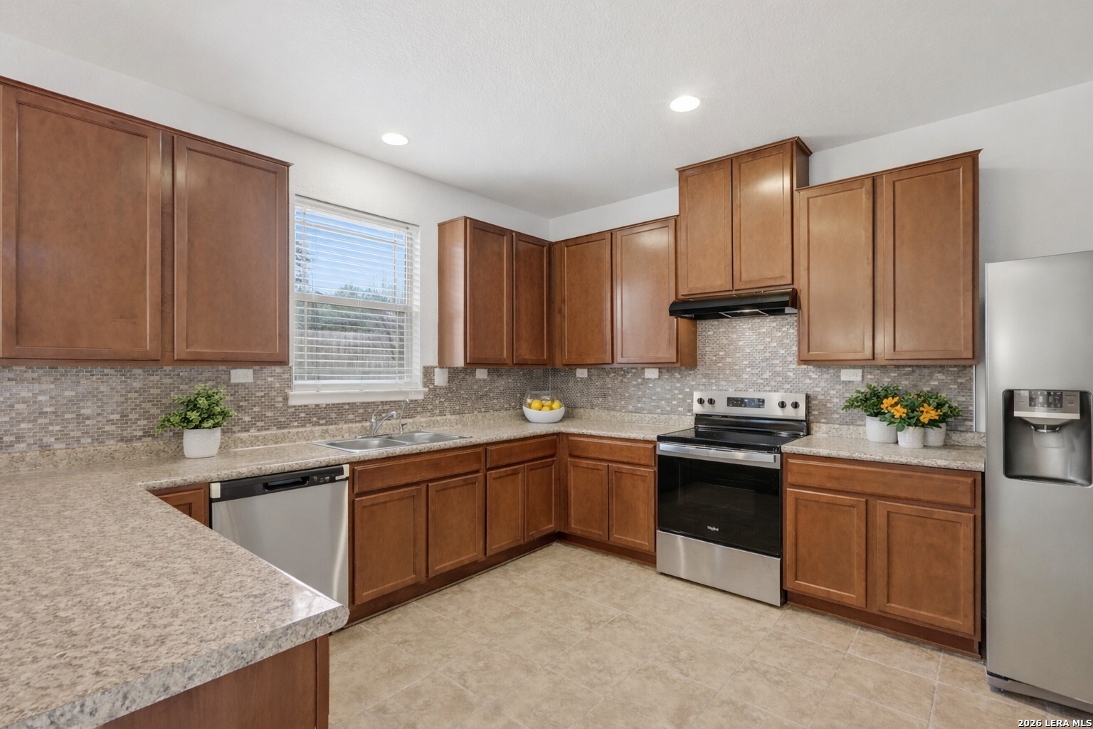 9819 Hawk Shore Converse, TX 78109 - Photo 7 of 26 a kitchen with granite countertop sink stainless steel appliances and cabinets