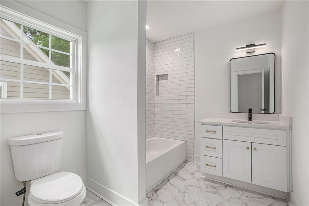 1721 South Gordon Street Southwest Atlanta, GA 30310 - Photo 40 of 44 a bathroom with a toilet a sink a tub and mirror