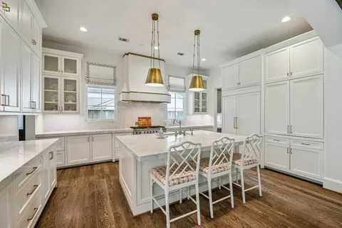 a kitchen with stainless steel appliances a sink a stove a window and cabinets
