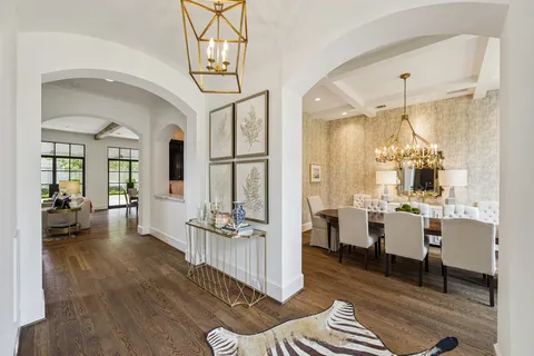 a living room with furniture a dining table and a chandelier