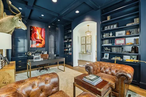 a living room with furniture a rug and a bookshelf