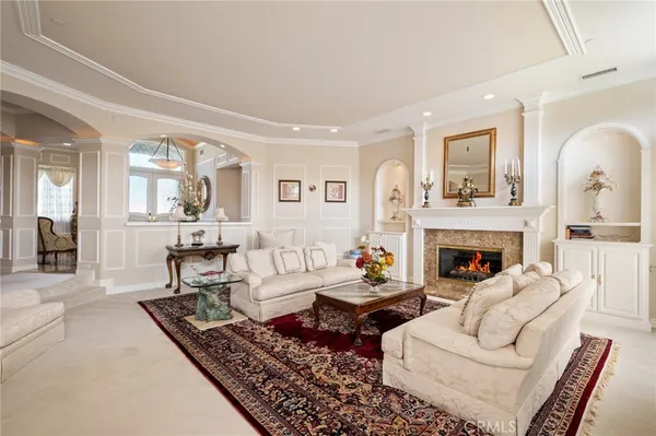 a living room with furniture a fireplace and a large mirror