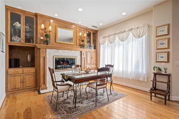 an open kitchen with granite countertop a stove and white cabinets with wooden floor