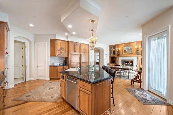 a view of a kitchen with kitchen island stainless steel appliances a sink and living room view