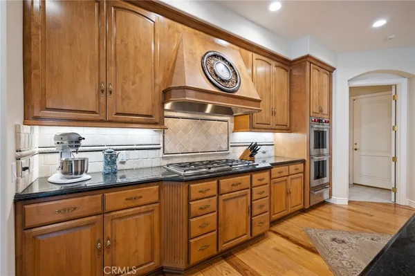 a kitchen with stainless steel appliances granite countertop a sink and dishwasher with white cabinets