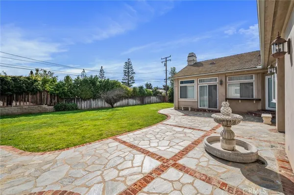 a backyard of a house with plants and large trees