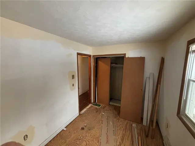 a view of hallway with stainless steel appliances wooden floor and more cabinets