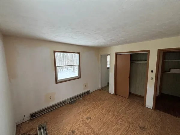 a view of an empty room with closet and a window