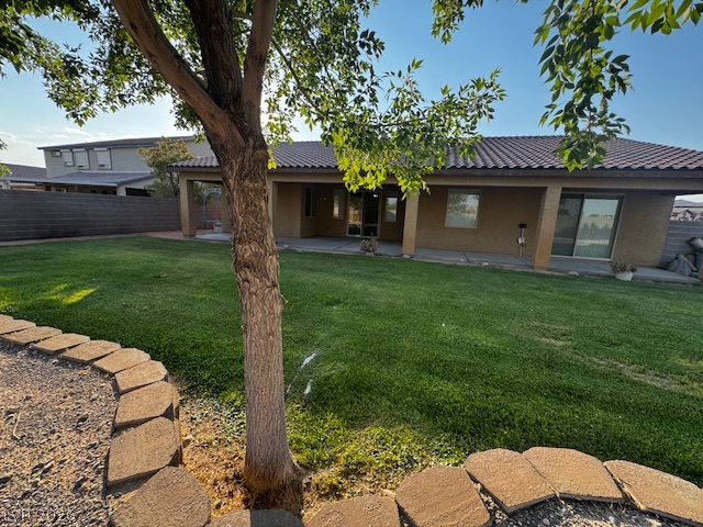 3744 River Heights Lane Logandale, NV 89021 - Photo 11 of 17 A spacious grassy yard provides ample outdoor living space, featuring a covered patio for shaded relaxation.