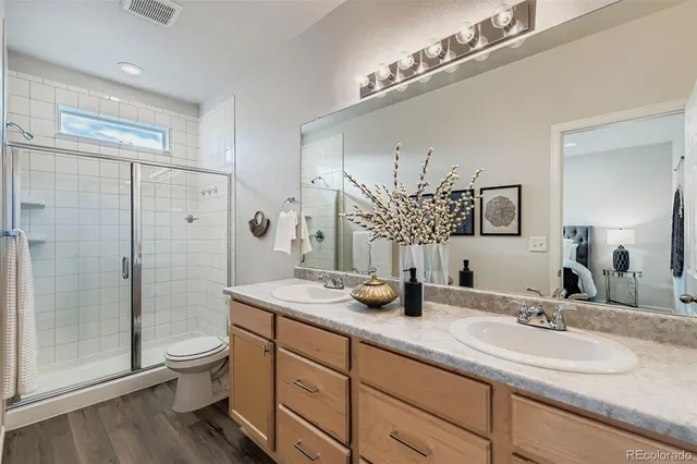 a bathroom with double vanity sink toilet and shower