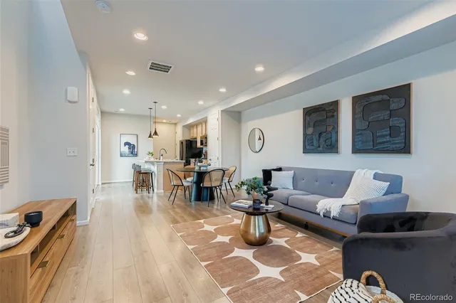 a living room with furniture and view of kitchen