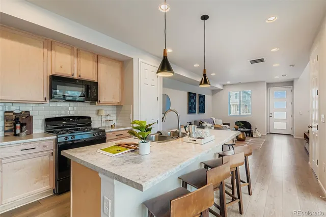 a kitchen with a stove a sink a microwave a dining table and chairs