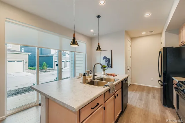 a kitchen with a sink a counter top space a large window and stainless steel appliances