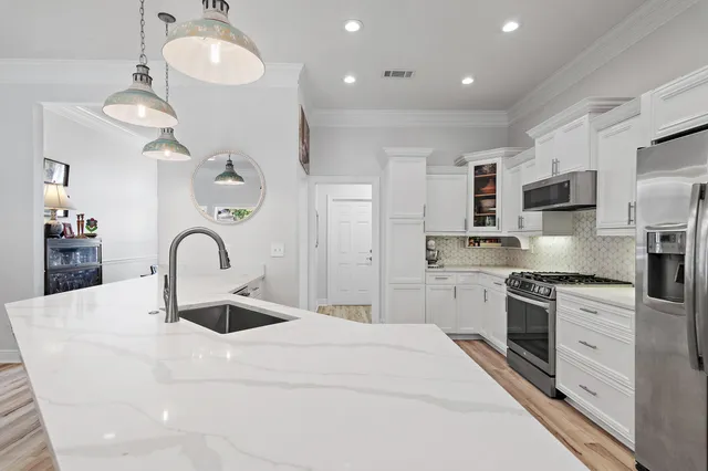 a kitchen with kitchen island stainless steel appliances a sink and stove