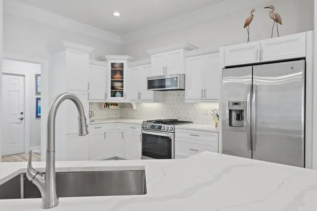 a kitchen with a refrigerator sink and white cabinets