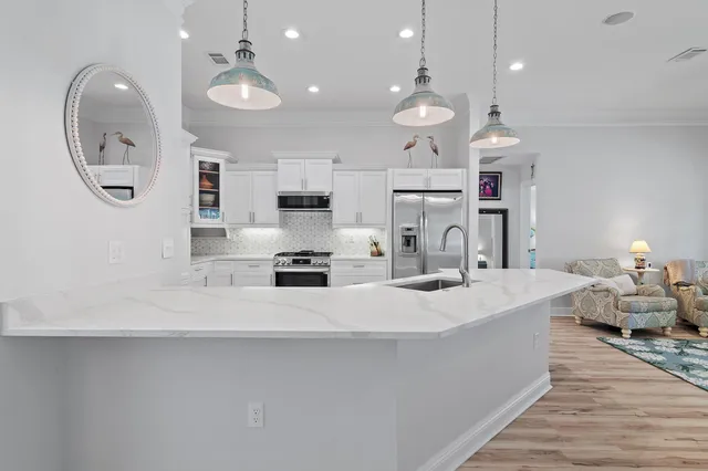 a large white kitchen with lots of counter space and refrigerator