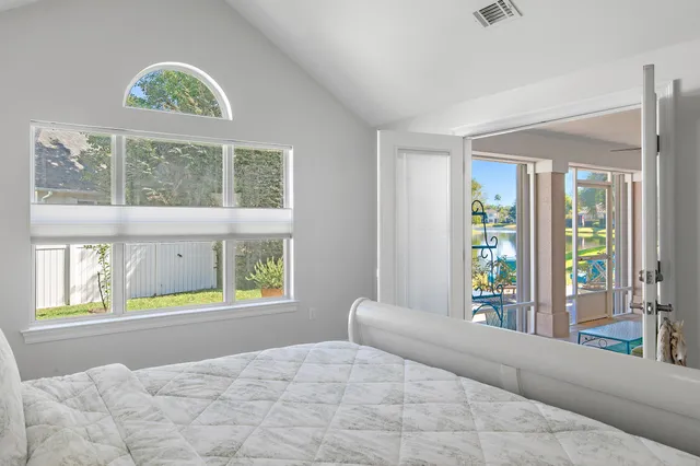 a bedroom with a bed and a large window