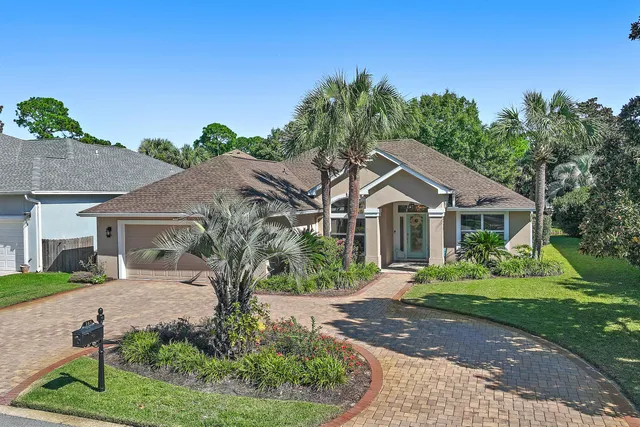 a front view of a house with a yard and potted plants