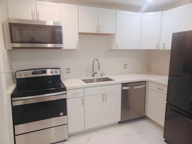 Kendall Green Pompano Beach, FL 33060 - Photo 3 of 8 a kitchen with cabinets stainless steel appliances and a sink