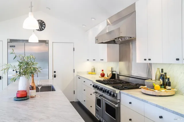 a kitchen with stainless steel appliances granite countertop a stove a sink and a refrigerator