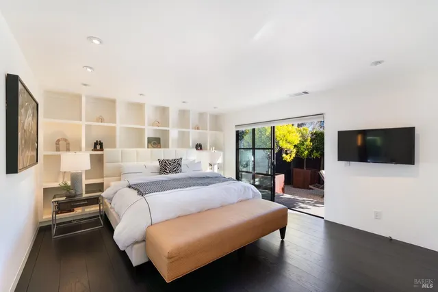 a bedroom with a bed and a flat screen tv
