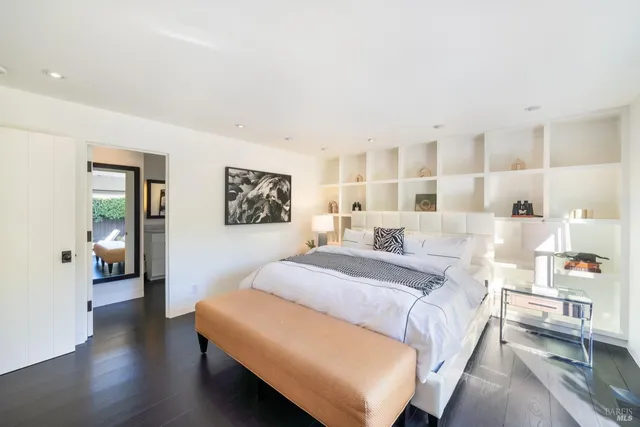 a spacious bedroom with a bed and wooden floor