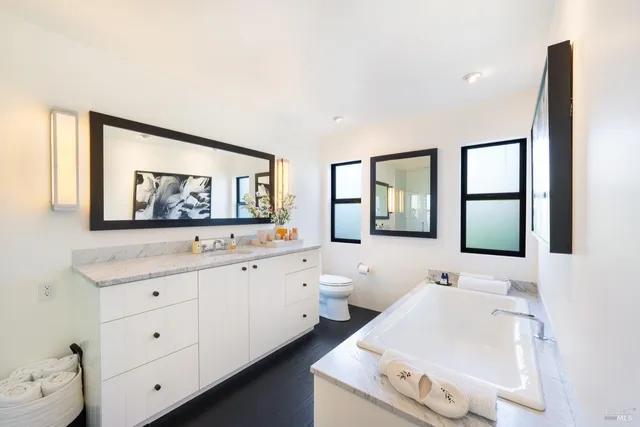 a spacious bathroom with double vanity and a large mirror