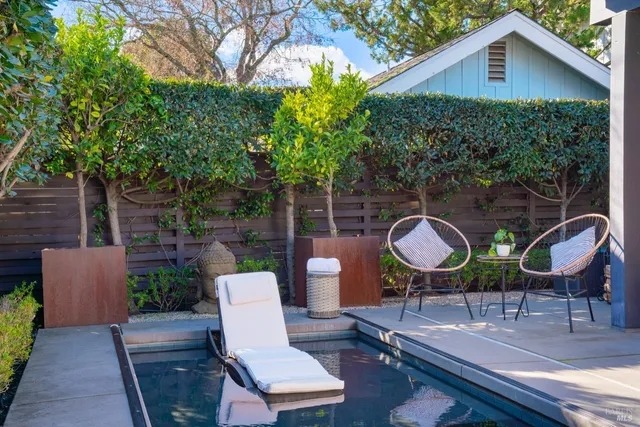 a view of a chairs and table in backyard