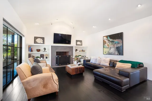 a living room with furniture a flat screen tv and a fireplace