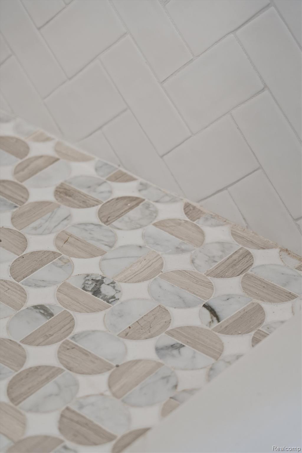 347 Highland Avenue Rochester, MI 48307 - Photo 25 of 59 Decorative stone tile with a split-face oval pattern, complemented by white subway tile in a herringbone arrangement