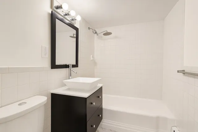 a bathroom with a sink a toilet and shower