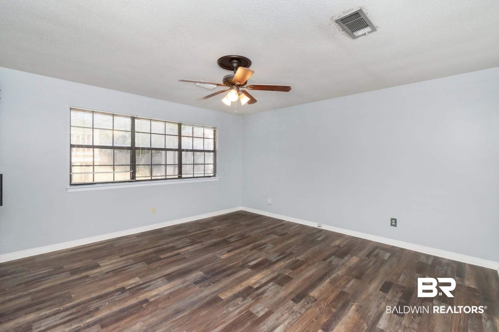 8304 Champlain Circle Mobile, AL 36695 - Photo 23 of 46 Empty room featuring ceiling fan, dark hardwood / wood-style flooring, and a textured ceiling