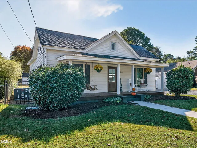 a front view of a house with a garden and plants