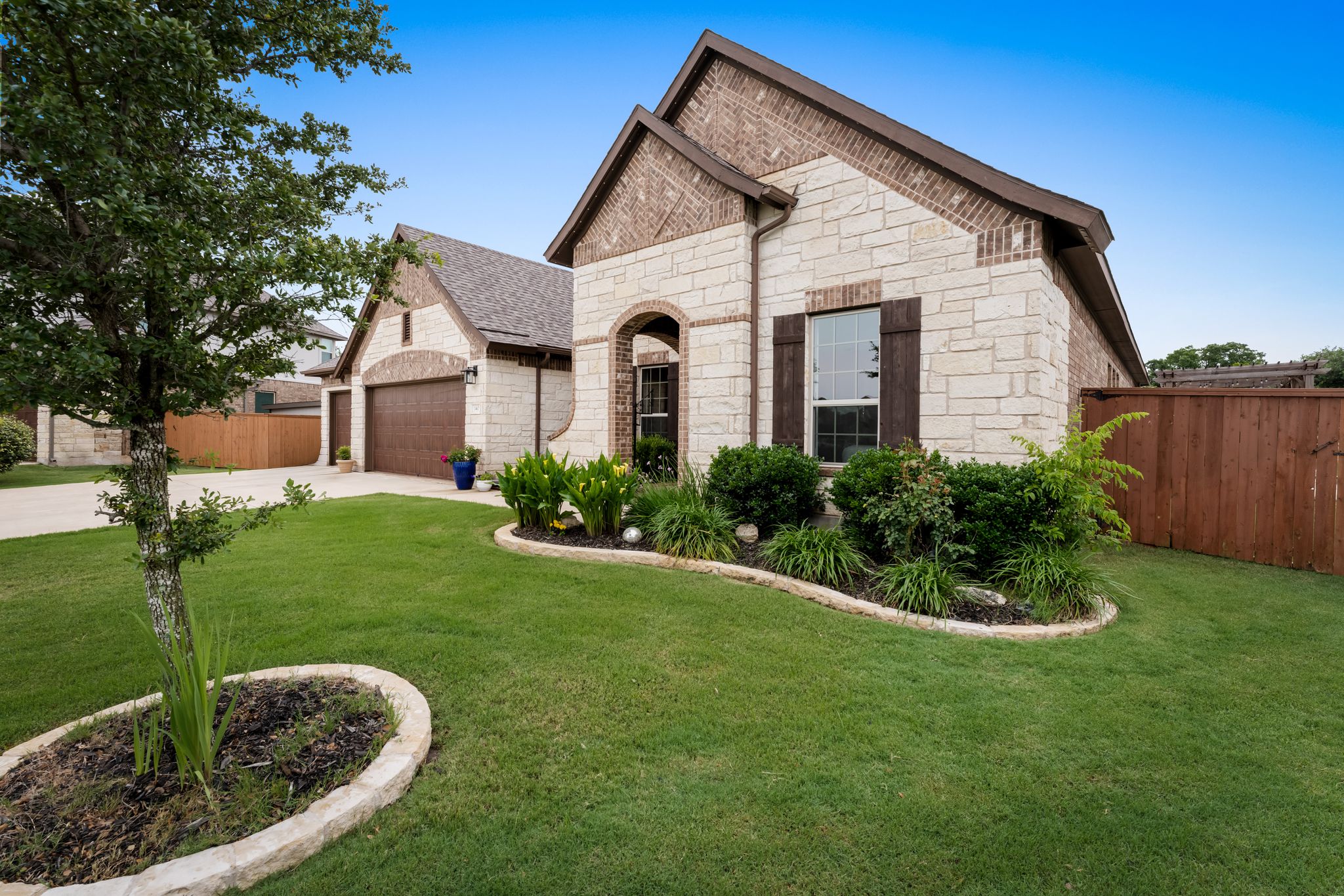 140 Waterloo Cove Georgetown, TX 78628 - Photo 2 of 40 A well-manicured lawn and a stone-clad exterior enhance this charming single-story residence.