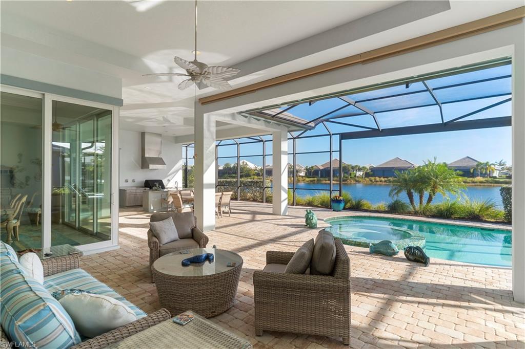 6254 Lightbourn Way Naples, FL 34113 - Photo 12 of 34 a living room with patio furniture and a garden