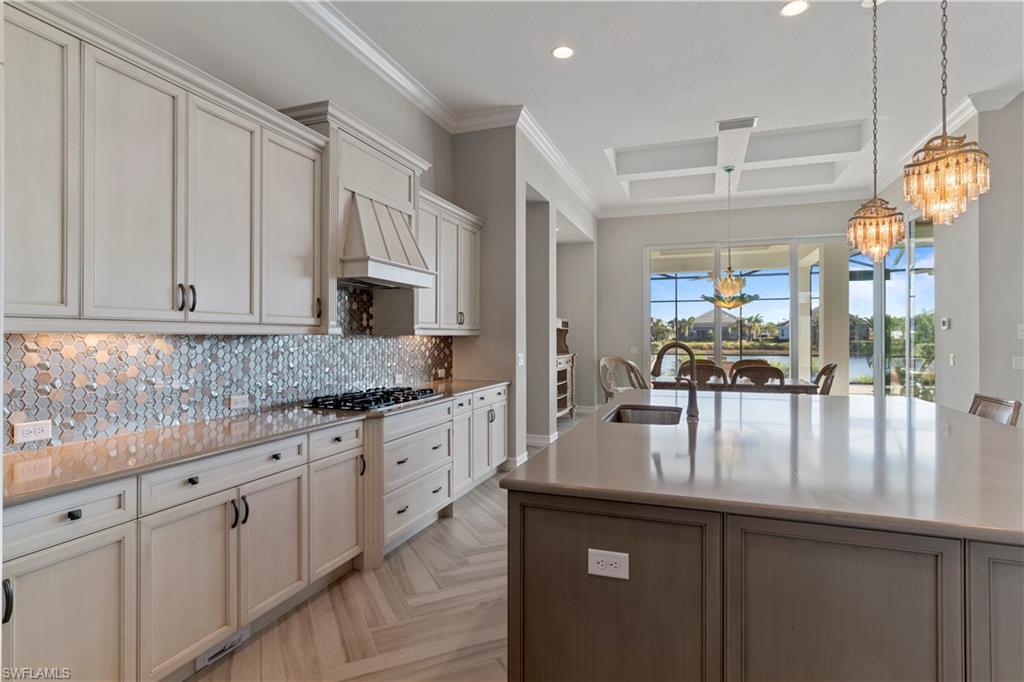 6254 Lightbourn Way Naples, FL 34113 - Photo 16 of 34 a kitchen with stainless steel appliances granite countertop a sink dishwasher and white cabinets with wooden floor